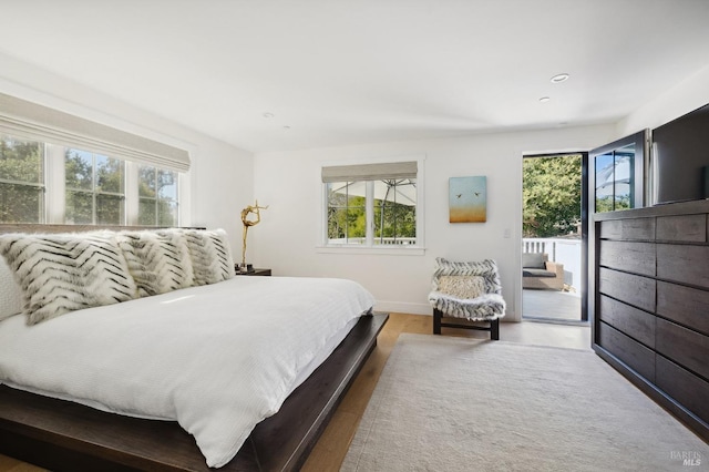 bedroom featuring baseboards, access to outside, recessed lighting, and wood finished floors