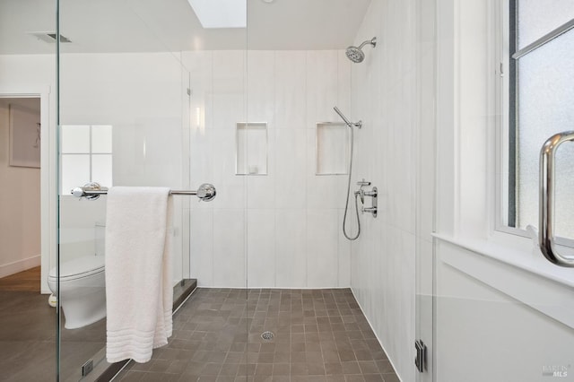 full bathroom with a wealth of natural light, visible vents, a stall shower, and toilet