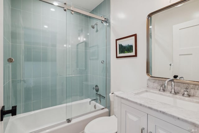 bathroom featuring toilet, shower / bath combination with glass door, and vanity