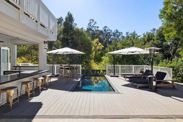 view of pool with an outdoor living space, a deck, and outdoor dry bar