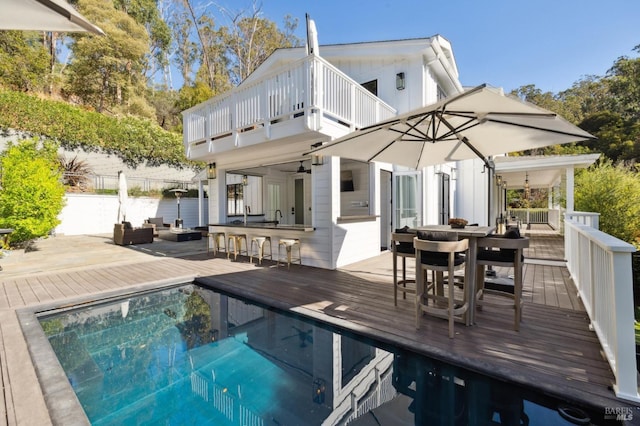 back of house with outdoor dry bar, an outdoor hangout area, a deck, and ceiling fan
