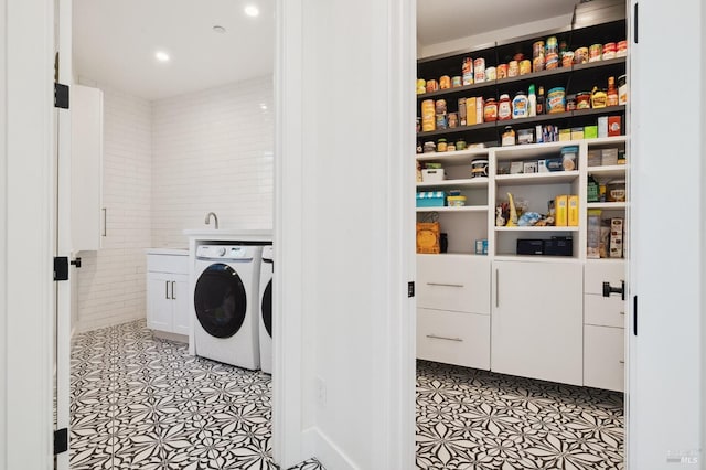 washroom featuring light tile patterned flooring, cabinet space, and independent washer and dryer