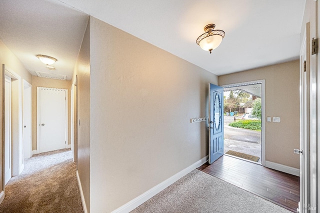 carpeted entryway featuring baseboards