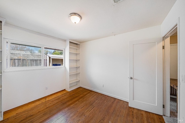 interior space featuring baseboards and wood finished floors