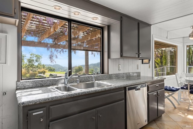 kitchen featuring a sink, dishwasher, and light tile patterned flooring