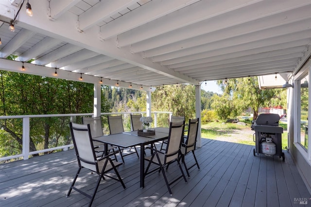 deck featuring outdoor dining area and a grill