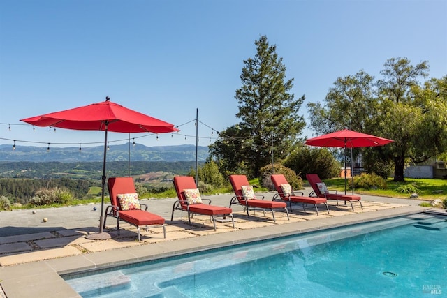 pool with a patio and a mountain view