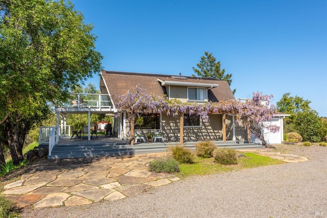 view of front of property with covered porch, a deck, and a balcony