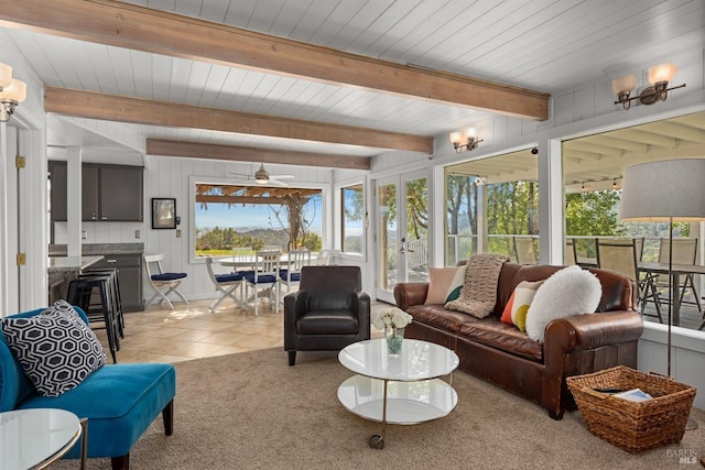 living room featuring light tile patterned floors, ceiling fan, light carpet, and beam ceiling