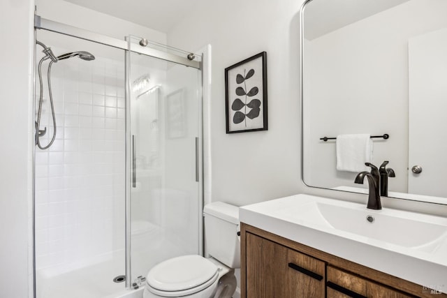 full bath with a shower stall, vanity, and toilet