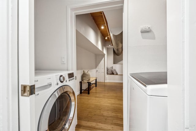 clothes washing area featuring washer / clothes dryer, baseboards, laundry area, and wood finished floors