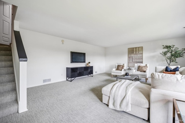 living room featuring stairs, visible vents, and carpet floors