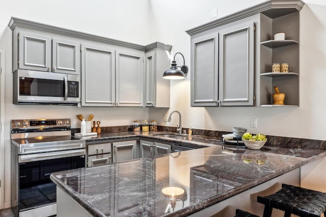 kitchen with open shelves, a peninsula, dark stone counters, stainless steel appliances, and gray cabinets