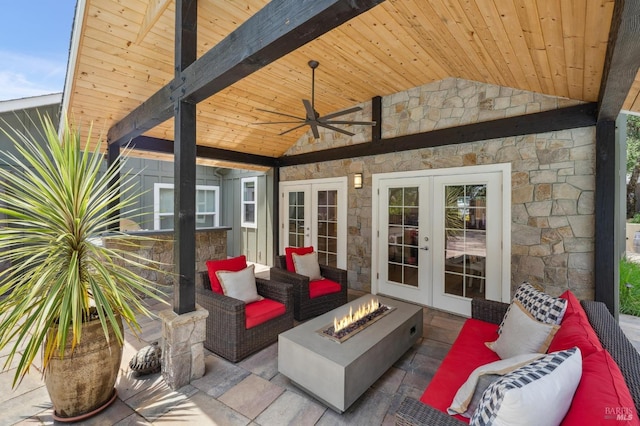 view of patio with ceiling fan, french doors, and an outdoor living space with a fire pit