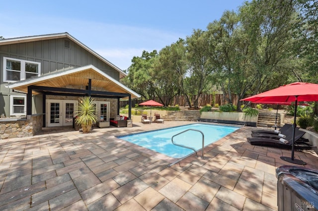 view of swimming pool with an outdoor living space, a patio area, french doors, a fenced in pool, and fence