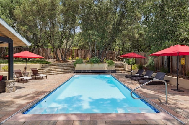 view of swimming pool with a fenced in pool, a fenced backyard, and a patio area