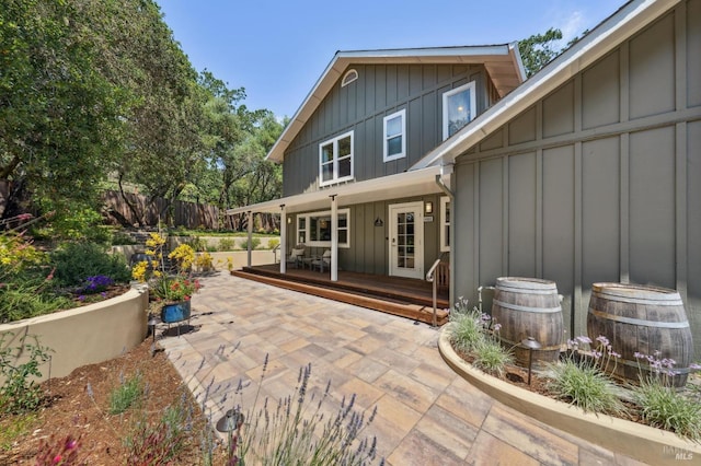 rear view of property with board and batten siding and fence