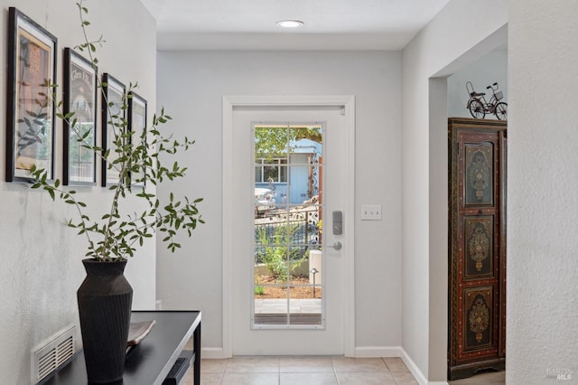 entryway with light tile patterned floors and baseboards