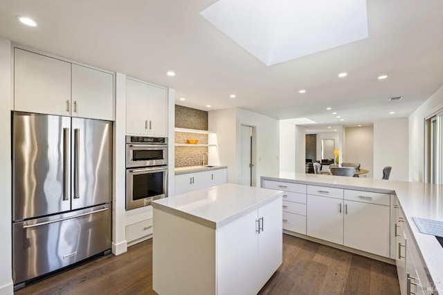 kitchen with light countertops, stainless steel appliances, a center island, and recessed lighting