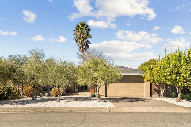obstructed view of property with stucco siding, aphalt driveway, fence, and an attached garage