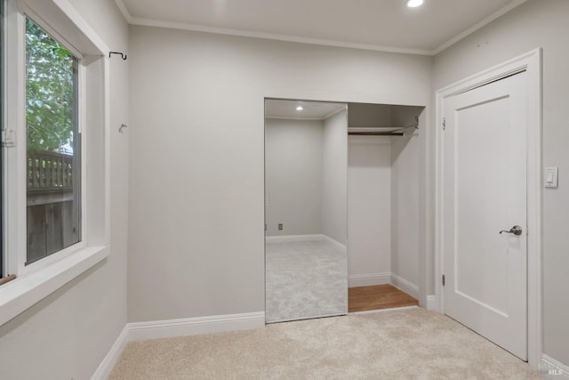 unfurnished bedroom featuring carpet flooring, ornamental molding, and baseboards