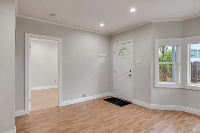 foyer featuring ornamental molding, baseboards, light wood finished floors, and recessed lighting