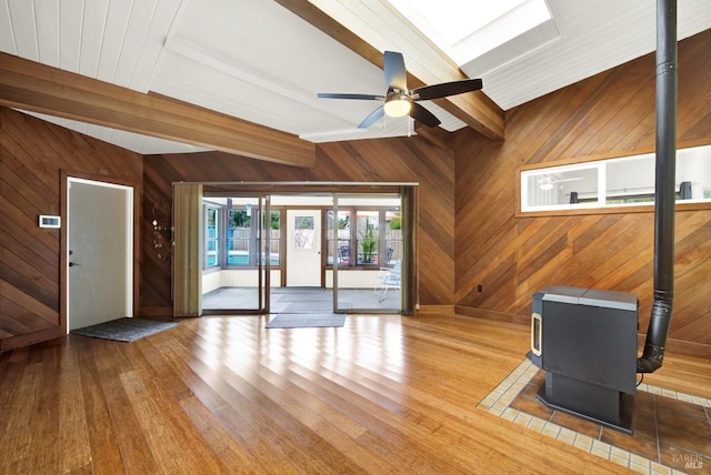 148 Kerns Ct, Napa, CA 94558 - unfurnished living room featuring a wood stove, beamed ceiling, wood finished floors, ceiling fan, and wooden walls