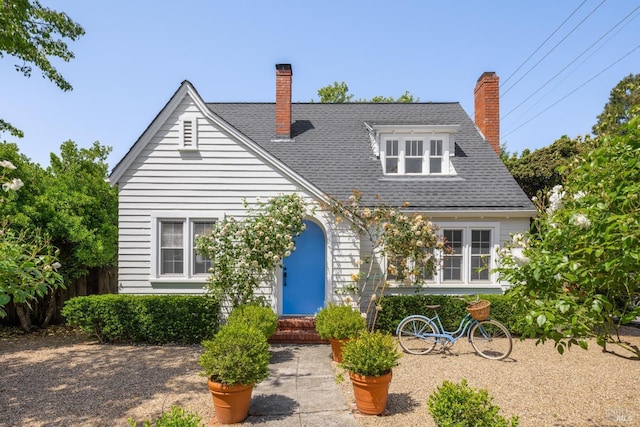 view of front of home featuring a chimney and roof with shingles