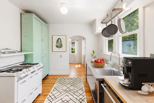 331 1st St, Healdsburg, CA 95448 - kitchen with a sink, light countertops, arched walkways, green cabinets, and light wood-style floors