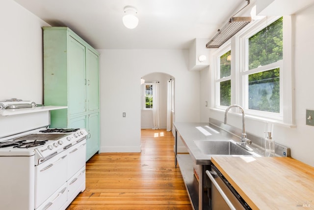 331 1st St, Healdsburg, CA 95448 - kitchen featuring arched walkways, a healthy amount of sunlight, a sink, green cabinetry, and light wood-style floors