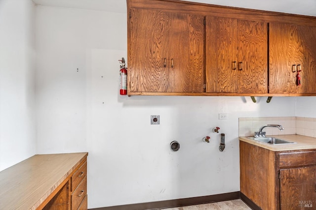 washroom with electric dryer hookup, a sink, and cabinet space