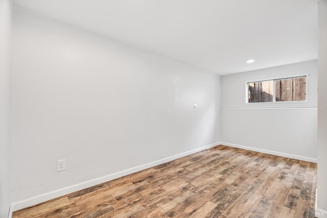 unfurnished room with recessed lighting, baseboards, and wood finished floors