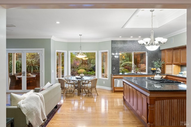 kitchen featuring light wood-style flooring, a sink, plenty of natural light, and crown molding