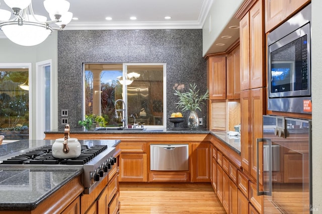 kitchen with crown molding, wine cooler, a chandelier, a sink, and appliances with stainless steel finishes