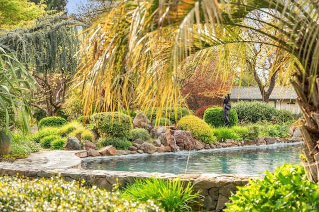 view of home's community featuring a garden pond
