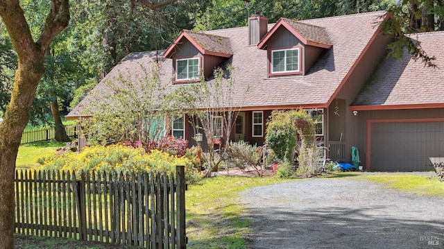 view of front of house with a front yard, a chimney, fence, an attached garage, and gravel driveway