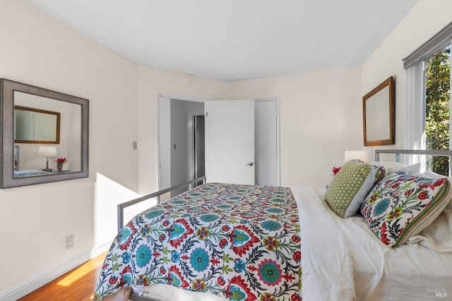 bedroom featuring wood finished floors and baseboards
