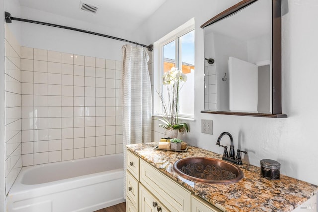 bathroom with shower / bath combo, vanity, and visible vents