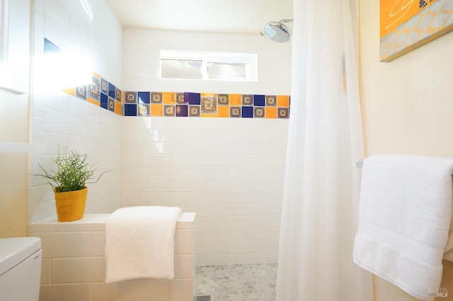 full bath featuring toilet and tiled shower