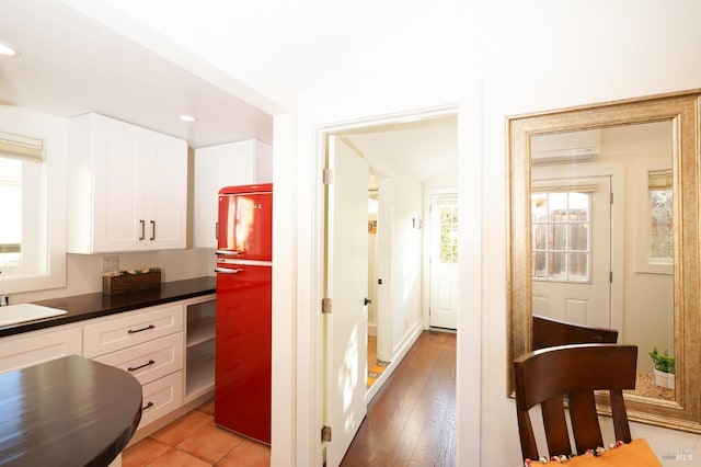kitchen featuring white cabinets, recessed lighting, a sink, dark countertops, and a wall mounted air conditioner