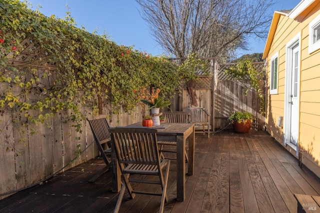 deck featuring outdoor dining space and fence