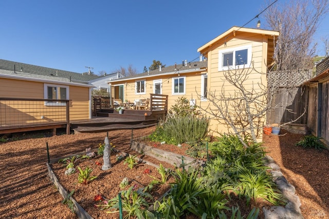 back of property with fence and a deck