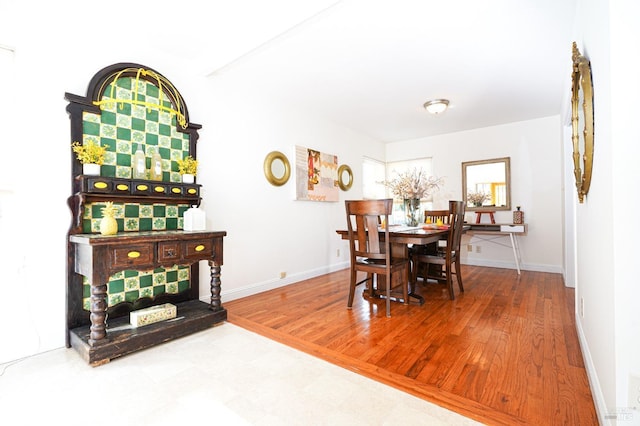 dining area with baseboards and wood finished floors