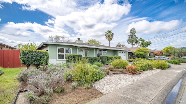 single story home with fence, an attached garage, a chimney, and stucco siding