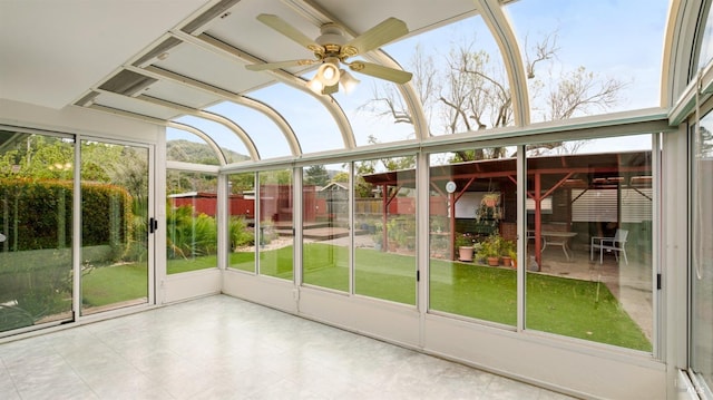 unfurnished sunroom featuring plenty of natural light and a ceiling fan