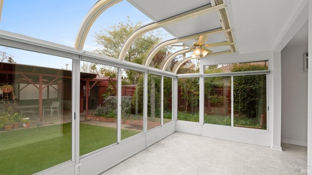 unfurnished sunroom with ceiling fan