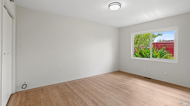 empty room featuring visible vents and light wood-style flooring