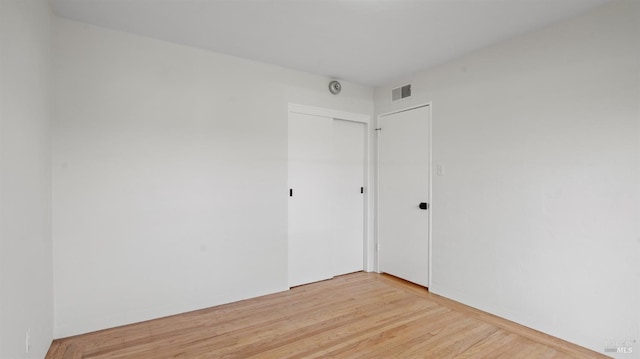 empty room featuring visible vents and light wood-style flooring