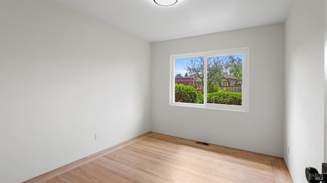 empty room featuring wood finished floors and visible vents