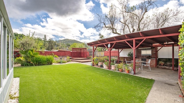 view of yard featuring fence, a patio area, and a mountain view